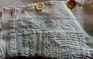 close up of beige smock sleeve with brown and beige buttons
